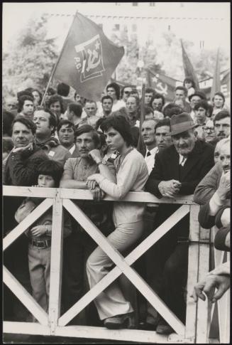 A large crowd of Italian Communist Party supporters waiting behind white gates