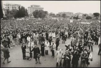 View of a large crowd behind barriers, and press and film crews in front of them, out in support of the Italian Communist party