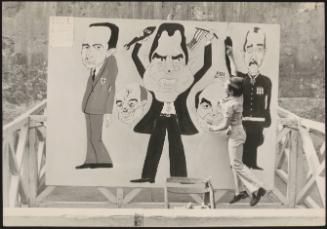 A boy removes darts from caricatures of Richard Nixon and other US figures, at an Italian Democratic Socialist Party (PSDI) event