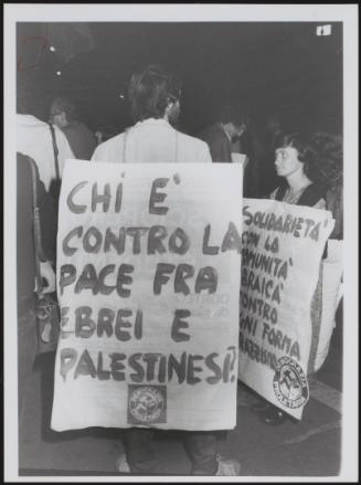 A demonstrator wears a protest placard highlighting the Israeli–Palestinian conflict