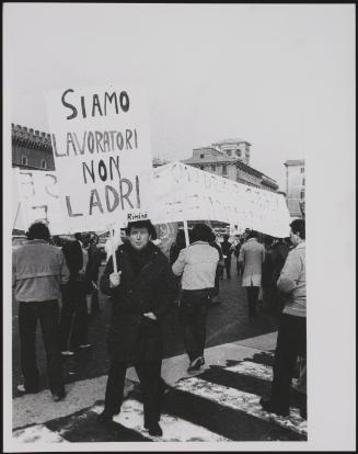 A worker holds up a placard at a demonstration