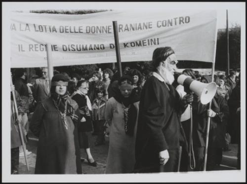 A man in a caricature mask of Iranian leader Komeini, leading a protest to highlight the plight of women under his regime