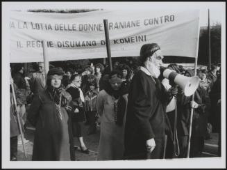 A man in a caricature mask of Iranian leader Komeini, leading a protest to highlight the plight of women under his regime