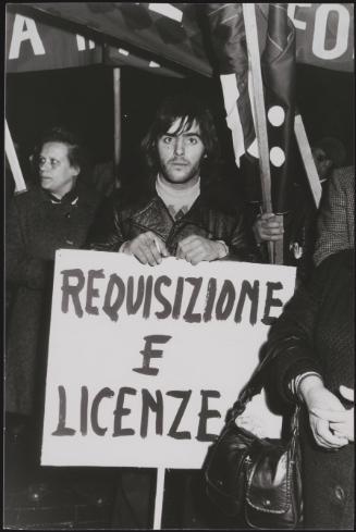 Young man holding a banner that reads, 'requisition and licenses'