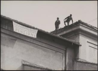 Squatters having scaled a roof put out a banner calling for better housing