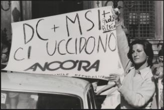 A woman holds up a poster in protest against the Christian Democracy party and the The Italian Social Movement party