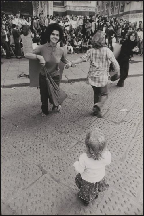A young girl watches a feminist demonstration