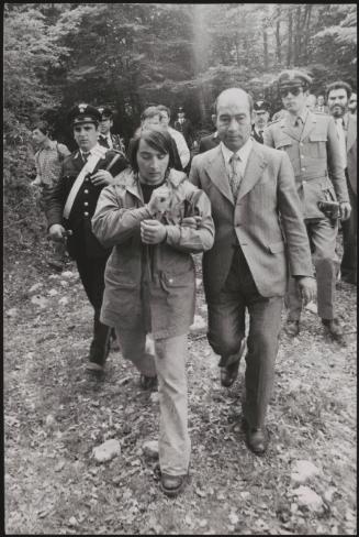 Alessandro D'Intino is led away by policemen in the aftermath of a gun battle between the police and neo-fascists on L ' Rascino Plateau in which right-wing extremist Giancarlo Esposti was shot dead
