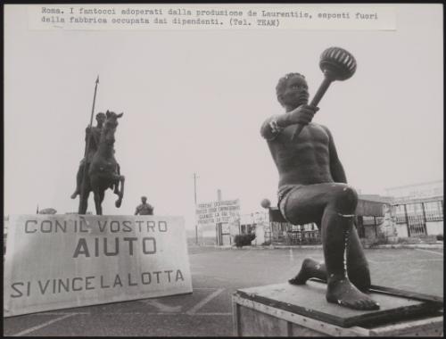 Theatrical props and a banner reading: 'With your help we will win the fight' outside the occupied De Laurentiis factory in Cinecittà, Rome