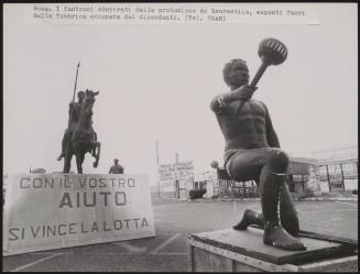 Theatrical props and a banner reading: 'With your help we will win the fight' outside the occupied De Laurentiis factory in Cinecittà, Rome