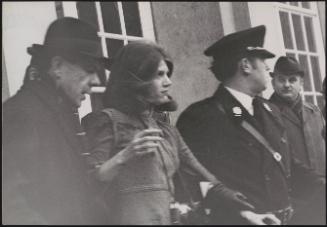 A young demonstrator or journalist is led away by Italian police in Italian parliament after she disrupted the visit by British prime minister Harold Macmillan