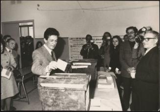 PCI leader Enrico Berlinguer placing his vote at a polling station for the cameras