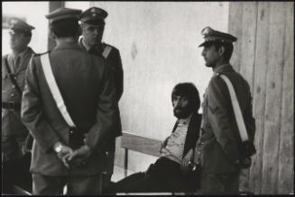 A member of NAP, guarded by four police men 