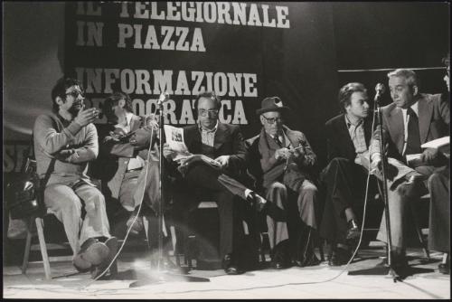 From left Preco, Camillus Benevento, Roberto Calvi, Terracini, Gabriele Isman and Annibale Paloscia, on a stage, behind them a banner reads 'The news in the square - democratic information'