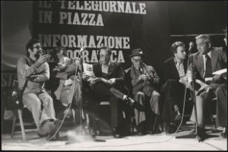 From left Preco, Camillus Benevento, Roberto Calvi, Terracini, Gabriele Isman and Annibale Paloscia, on a stage, behind them a banner reads 'The news in the square - democratic information'