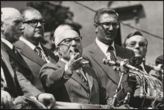 Politicians standing at microphones