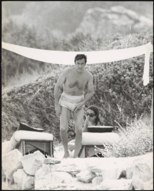 Paparazzi photo of the socialite Ira Fürstenberg with a male friend, trying to sunbathe in a secluded spot at the beach