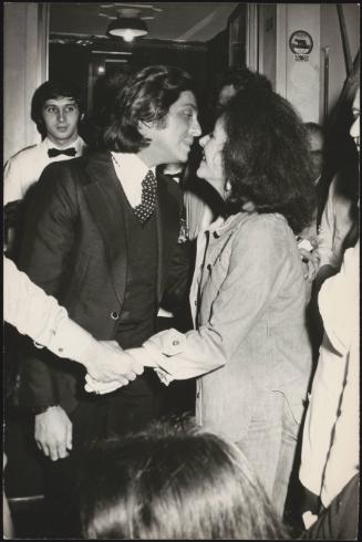Designer Valentino and actress Elizabeth Taylor embrace at a party 