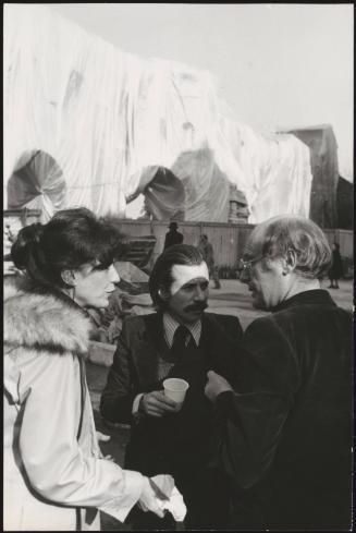 The Wall – Wrapped Roman Wall, Via Veneto and Villa Borghese, Rome, Italy, 1973-74, the artist Jeanne-Claude stands by with two other gentlemen drinking wine and eating porchetta. 