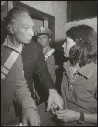 Politician Marco Pannella, flanked by two uniformed guards, 