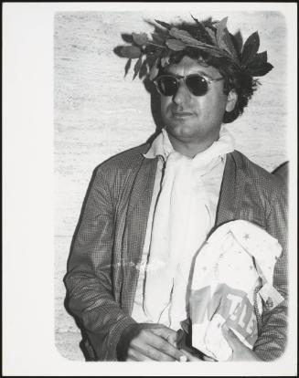 Poet Dario Bellezza wearing a laurel crown and sunglasses