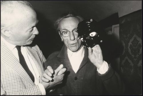 Eduardo De Filippo and companion. De Filipo holds up a mask.