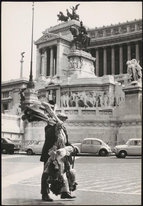 A man carries brooms and brushes to sell on the streets