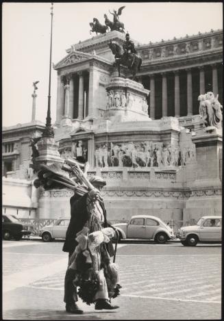 A man carries brooms and brushes to sell on the streets