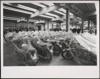 New Honda motorcycles lined up in a warehouse dry storage space