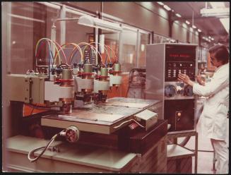An employee operating the electronic controls of a machine  