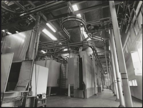 View of a factory interior showing tubes and sliding panels for painting products