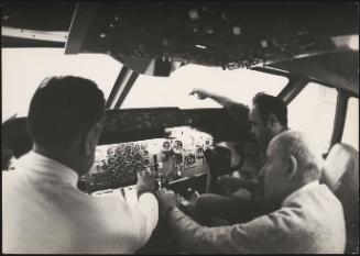 Three men in a aeroplane's cockpit  