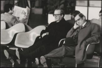 Two business men in an airport waiting lounge