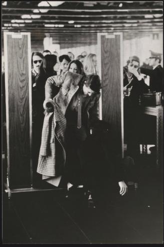 A security guard checks a passengers shoes as they go through a security gate at the airport