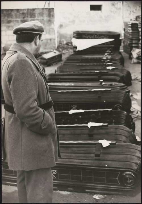 Sicilian man looks over rows of coffins containing victims from the Belice earthquake, 1968