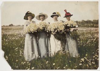 Four women wearing hats and holding daisies