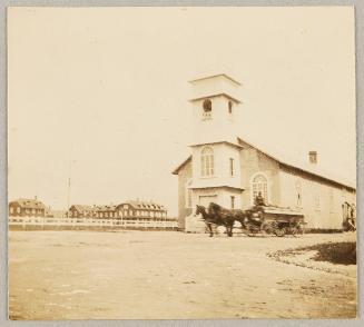 Horse drawn carriage on street outside school house