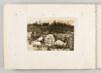 [Grave in rocky terrain, with trees and mountains behind] page 56 of The Doukhobors I album]