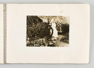 [Woman sitting at spinning wheel in lush garden, page 33 of The Doukhobors I album