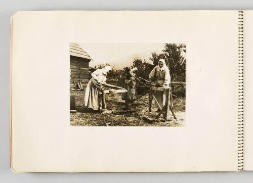 [Three smiling women cutting crops in yard, page 32 of The Doukhobors I album