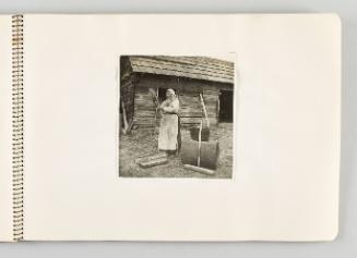 [Woman standing in yard and holding bundle of straw, page 31 of The Doukhobors I album