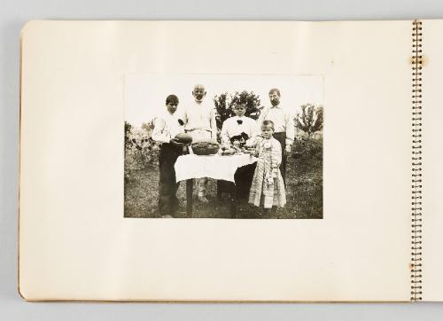 [Family gathered around table outside with food, page 6 of The Doukhobors I album]