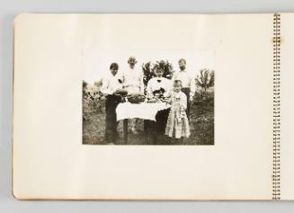 [Family gathered around table outside with food, page 6 of The Doukhobors I album]