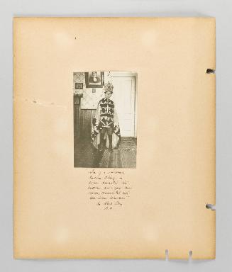 Son of a Siwash Indian chief in robe decorated with buttons and a yew-wood crown, ornamented with sea-lions whiskers, in Alert Bay, B.C. [Page 10 of Alert Bay, Queen Charlotte Islands, and Victoria, B.C. album]