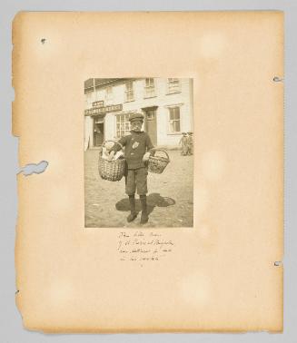 This little man of St. Pierre et Miquelon has lettuce for sale in his baskets [Page 72 of Children album]
