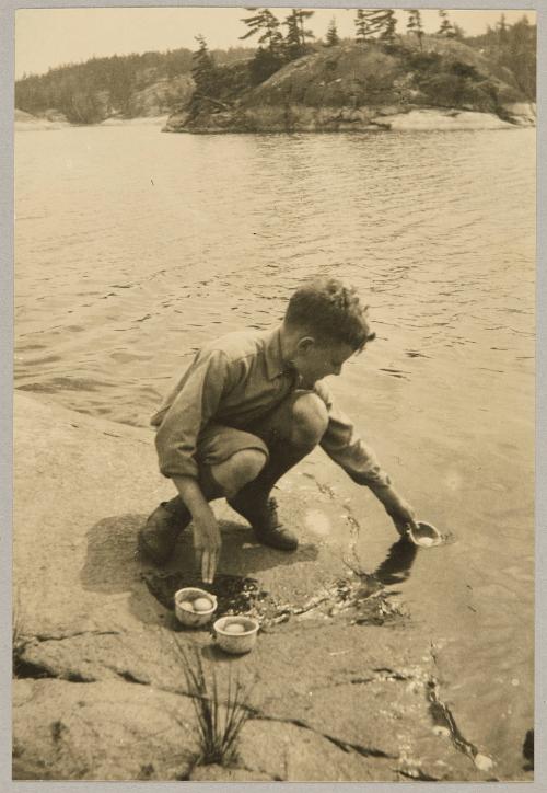 "Grimel Jr." all the way from Barcelona Spain, cooks the eggs for our lunch in the French river, Canada, + thinks he is having a holiday worth while.
