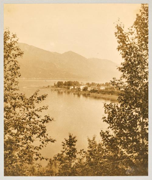 [View of lake seen between archway of greenery]