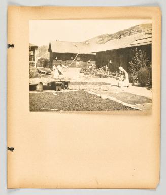 [Two women working with tools in a courtyard, in a Doukhobor community.] [Page 57 of The Doukhobors II album]