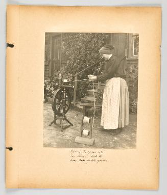 Spinning flax yarns into one thread. Note the home made bobbin spools. [Page 19 of The Doukhobors II album]