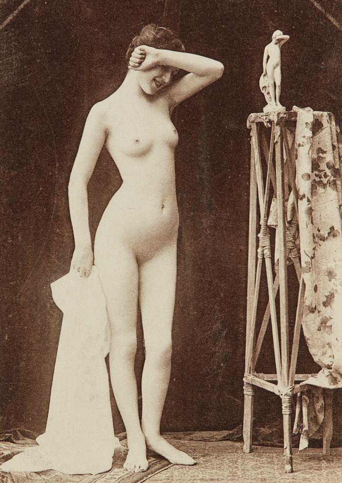 [Standing woman striking pose of sculpture on stand]